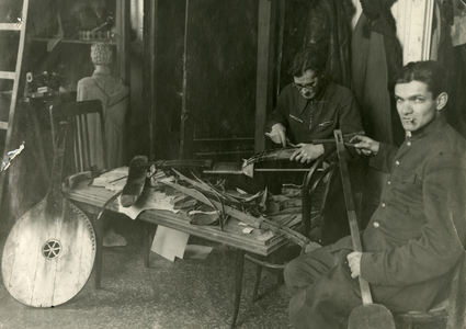 Сотрудник музея Ю.В.Кнорозов и зав. реставрационной мастерской А.А.Дмитриев реставрируют музыкальные инструменты. Фотография 1940-х гг. 